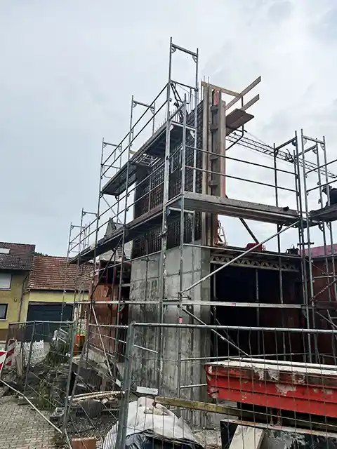 Rohbau eines mehrstöckigen Gebäudes mit Stahlbetonkern, umgeben von einem Baugerüst